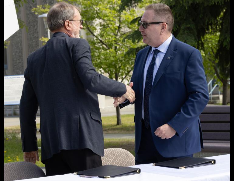 UAF Geophysical Institute Director Bob McCoy and Alaska Aerospace Corp. CEO John Oberst shake hands after signing a memorandum of understanding in front of the GI building on Thursday, June 10, 2025. UAF/GI photo by Bryan Whitten